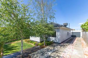 a small white house with trees in front of it at Oaklight Haven - Minutes to Geelong Waterfront & CBD in Hamlyn Heights