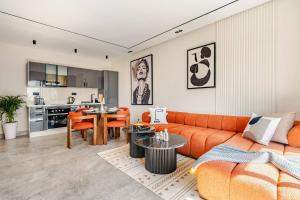 ein Wohnzimmer mit einem orangenen Sofa und einem Tisch in der Unterkunft CFC business • Coworking, gym, self check-in in Anfa