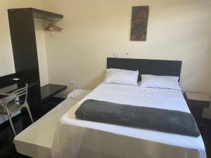 a bedroom with a large white bed with a black headboard at Bela Casa Stella Maris - Casa de Carrara 01 in Andradina +55 photos