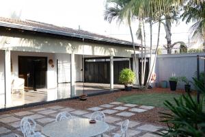 a patio with a table and chairs next to a building at Bela Casa Stella Maris - Casa de Carrara 01 in Andradina
