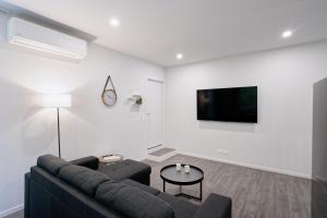 een woonkamer met een bank en een tv bij Recently Renovated Central Apartment in Dunedin