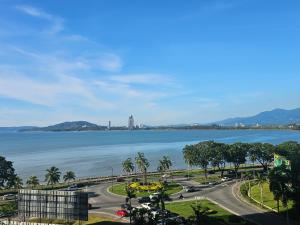 a view of the water and a city with palm trees at C&S BaySuites Homestay in Kota Kinabalu