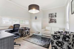 an office with a desk and a chair and a couch at Modern Family Retreat in Prime Williams Landing in Williams Landing