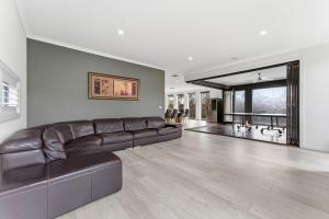 a large living room with a brown leather couch at Modern Family Retreat in Prime Williams Landing in Williams Landing