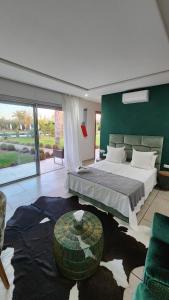 a bedroom with a large bed and a green wall at Villa Fima Kech in Marrakesh +76 photos