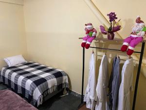a room with a bed and a shelf with teddy bears at kitinet centro econômico in Santo Antônio do Pinhal