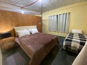 een slaapkamer met een groot bed en een raam bij kitinet centro econômico in Santo Antônio do Pinhal