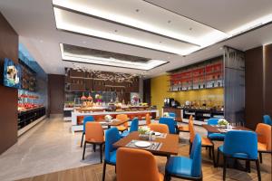 een restaurant met tafels en stoelen en een bar bij Hampton by Hilton Hefei Binhu in Hefei