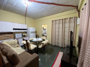 a living room with a couch and a table with chairs at kitinet centro econômico in Santo Antônio do Pinhal