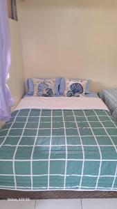 a bed in a room with a green and white mattress at relajate en buzios in Búzios +3 photos