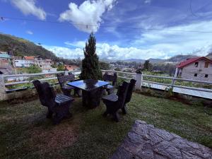 uma mesa e cadeiras sentadas em cima de um campo em Roshan Guest House em Nuwara Eliya