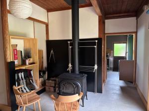 a living room with a stove and two chairs at A luxurious accommodation experience surrounded by nature in Okazaki