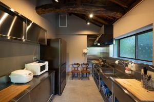 a kitchen with stainless steel appliances and a counter top at A luxurious accommodation experience surrounded by nature in Okazaki