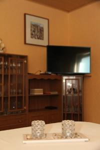 a living room with a tv and a table at Ferienhaus Am Weiher in Waltershausen