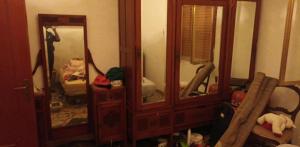 a room with a large wooden cabinet with mirrors at Margiii apart in Augusta
