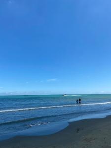 duas pessoas em pé na água na praia em Cabañas Kosta Azul em San Bernardo del Viento