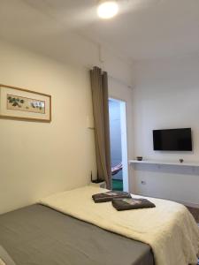 a bedroom with a bed and a flat screen tv at Suíte privativa Vila Dom Pedro in Paraty