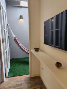 a living room with a television and a green carpet at Suíte privativa Vila Dom Pedro in Paraty +6 photos