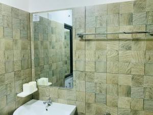 une salle de bain avec un lavabo et un miroir dans l'établissement Namunuku mount heaven cabana & resort,passara, à Passara 17 autres photos