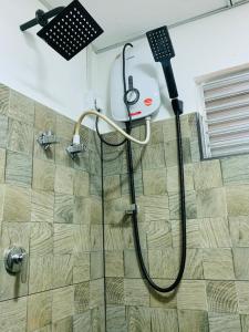 une douche dans une salle de bain avec une pomme de douche dans l'établissement Namunuku mount heaven cabana & resort,passara, à Passara