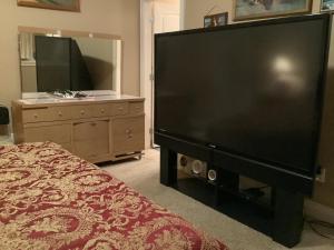 a large flat screen tv in a bedroom with a bed at Barry and Elaine in Abbotsford