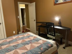 a bedroom with a bed and a desk and a table at Barry and Elaine in Abbotsford