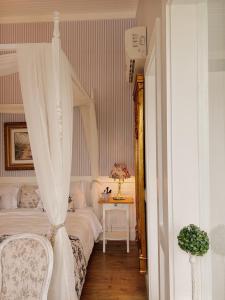 a bedroom with a bed and a table with a lamp at La Belle Provence in Itaipava