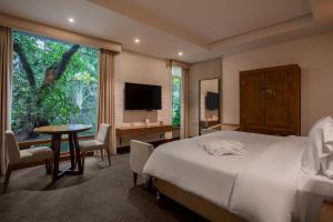 a bedroom with a bed and a desk and a large window at Alko Hotel Casa Nispero in Cali