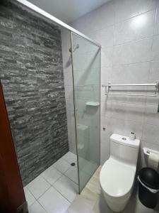 ein Badezimmer mit Toilette und Glasdusche in der Unterkunft Modern apartment a few steps from the Salinas esplanade in Salinas