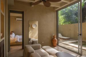 a living room with a couch and a large window at Arde La Selva in Santa Fe de Antioquia