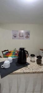 a tea kettle sitting on a counter top with some pots and pans at Shanti House Geribá in Búzios