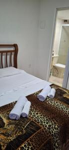 a bedroom with a bed with two towels on it at Shanti House Geribá in Búzios