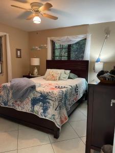 a bedroom with a bed and a ceiling fan at Tropical Jungle Bugelow in Naples