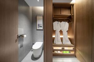 a bathroom with a toilet and a white robe at Chongqing Mansion Manyue Hotel in Chongqing +30 photos