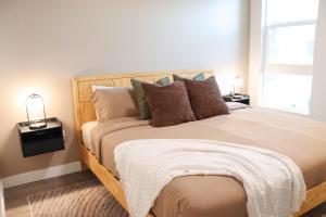a bedroom with a wooden bed with pillows at Pacific Paradise 10 Min from Disneyland With Pool & GYM in Tustin +66 photos