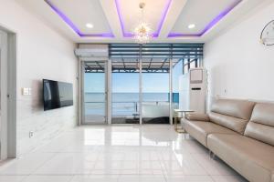 a living room with a couch and a view of the ocean at Yeongdeok Searest Pool Villa in Changsa-ri