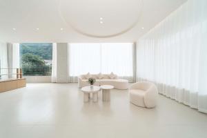 een woonkamer met witte meubels en een groot raam bij Yi Zhan Mountain Homestay in Xingping