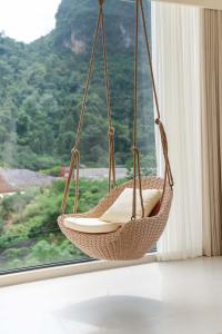 een rieten hangmat die uit een raam in een kamer hangt bij Yi Zhan Mountain Homestay in Xingping