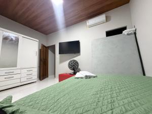 una habitación con una cama verde y una pantalla de proyección en Flat aconchegante a 50m da orla, en Bragança