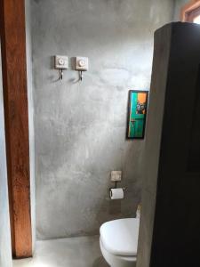 een badkamer met een wit toilet in een kamer bij Há Mar Chalés Corumbau in Prado