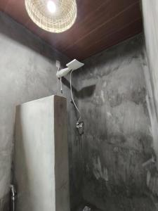 een douche in een badkamer met een licht op het plafond bij Há Mar Chalés Corumbau in Prado