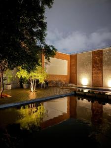 a house with a pond in front of it at Grande Hotel in Paranavaí