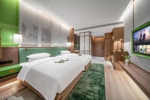 a bedroom with two beds and a flat screen tv at Chongqing Mansion Manyue Hotel in Chongqing