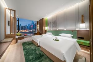 a bedroom with a large white bed with a green rug at Chongqing Mansion Manyue Hotel in Chongqing