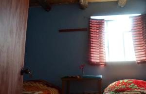 ein Schlafzimmer mit einer blauen Wand und einem Fenster in der Unterkunft Homestay Cordillera Blanca in Monterrey