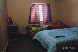 ein Schlafzimmer mit zwei Betten und einem Fenster in der Unterkunft Homestay Cordillera Blanca in Monterrey
