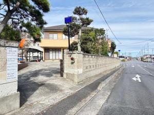 水户一棟貸しの宿 貸別荘 水戸ハウス Vacation Rental Mito House! Location is 1-2-55 Kanemachi Ibaraki Prefecture 場所は茨城県水戸市金町1-2-55です ドア横のキーボックスの番号はご予約後に,チェックイン情報を見る,をご覧下さい的一条空旷的街道，街道两旁是一堵墙，墙上长着一棵树。