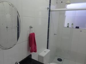 a white bathroom with a mirror and a toilet at Aconchegante in Peruíbe +7 photos