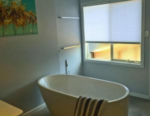 a bath tub in a bathroom with a window at Eastgarth in Venus Bay +4 photos