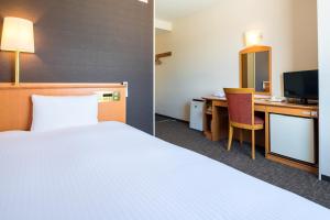 una habitación de hotel con una cama y un escritorio en Moriyama Art Hotel, en Moriyama